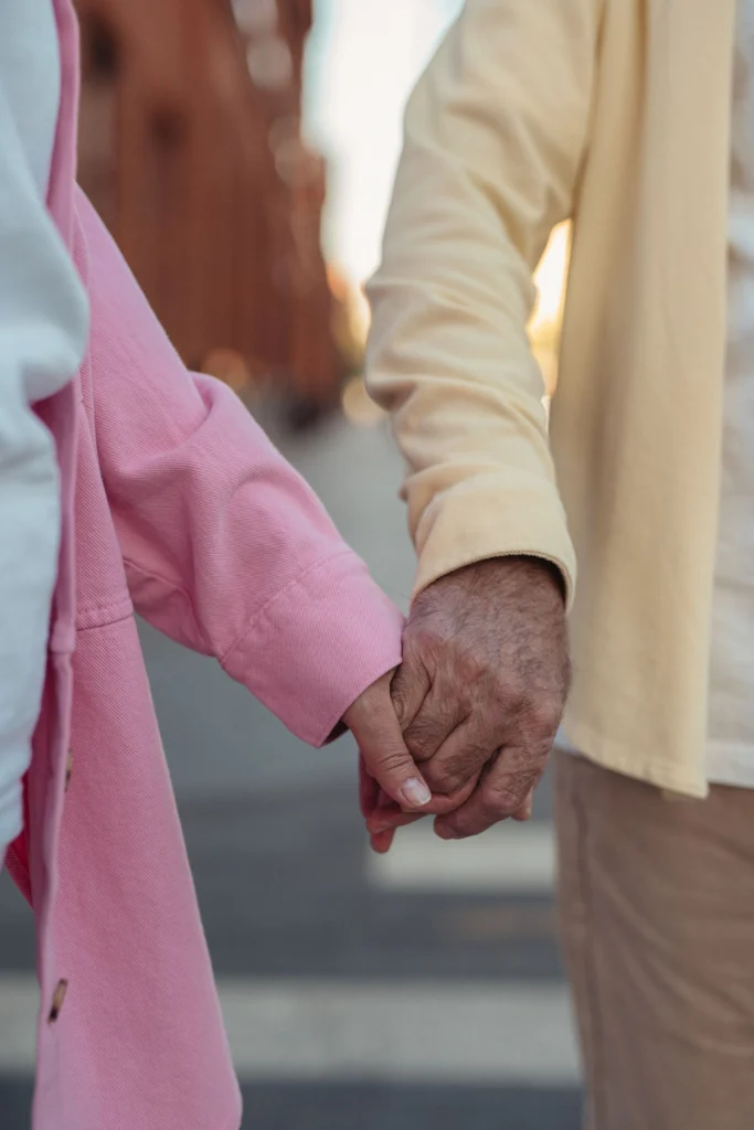 Two people walking outdoors together, hand in hand